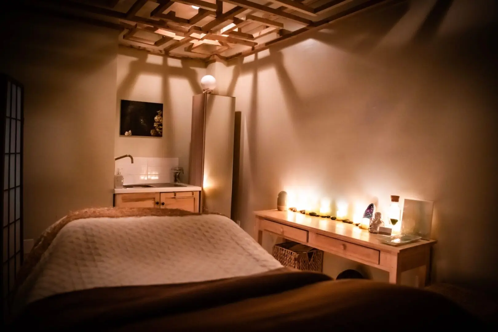 A bed room with candles lit in the corner
