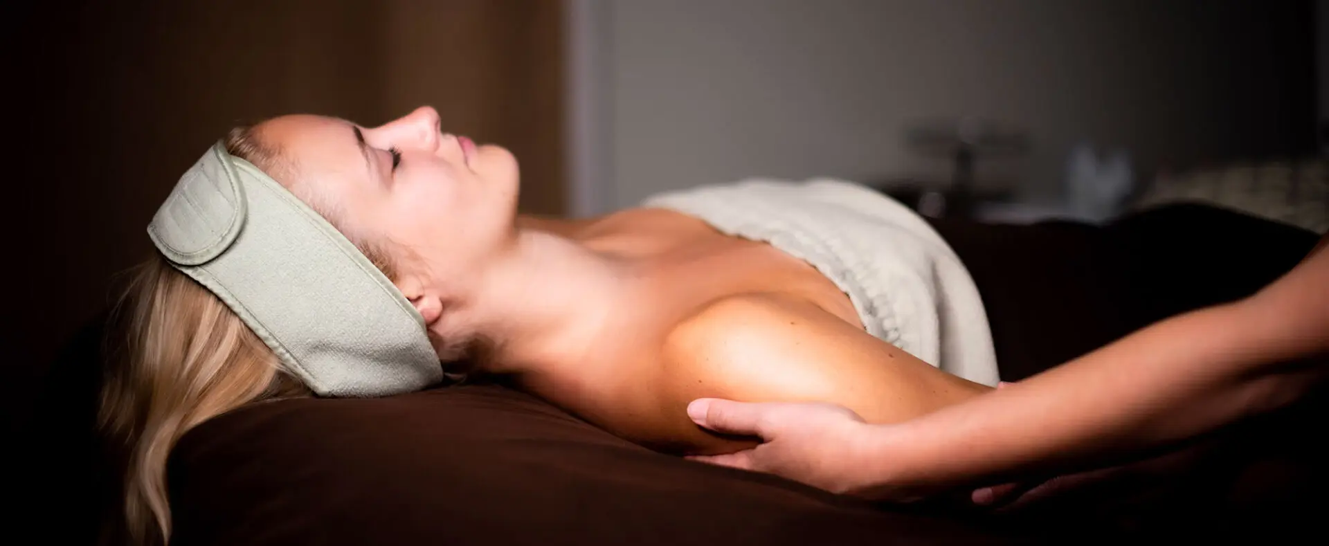 A woman laying on her stomach in the middle of a massage.