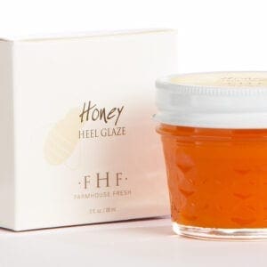 A jar of honey next to a box.