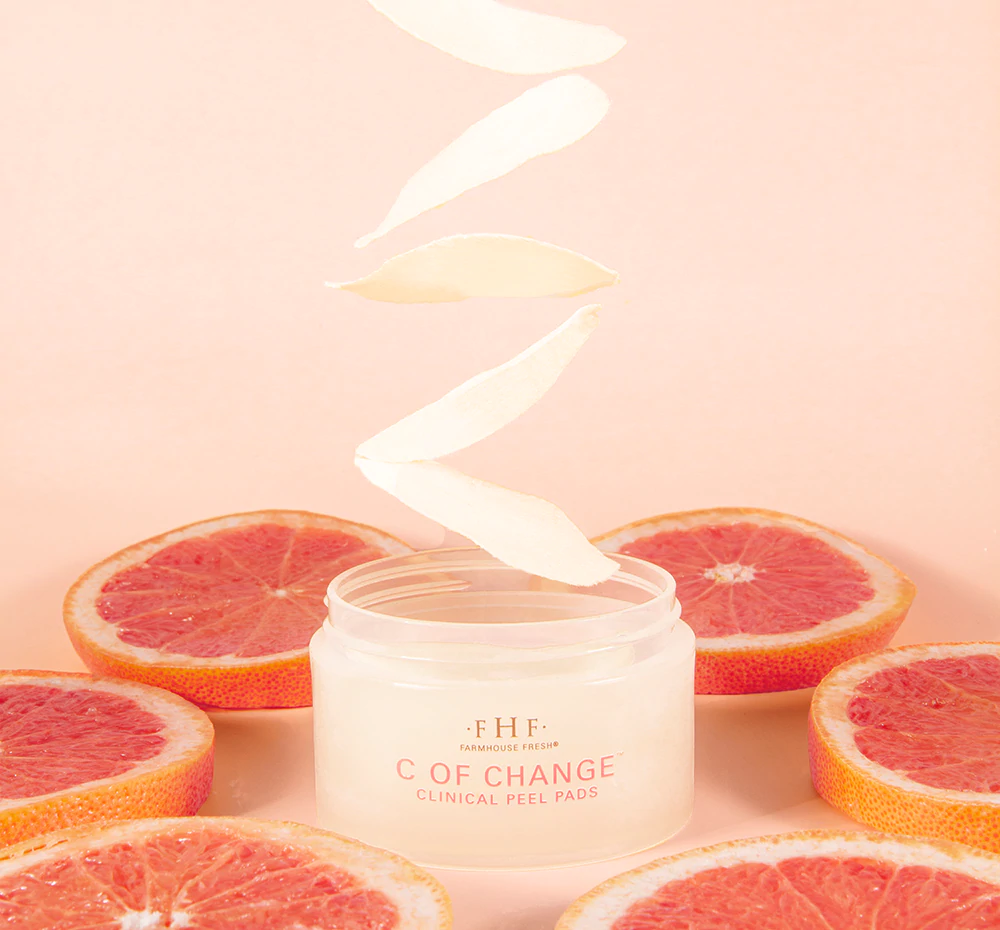 A jar of cream surrounded by grapefruit slices.