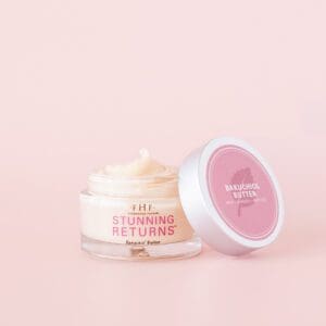 A pink and white container of cream sitting next to another container.