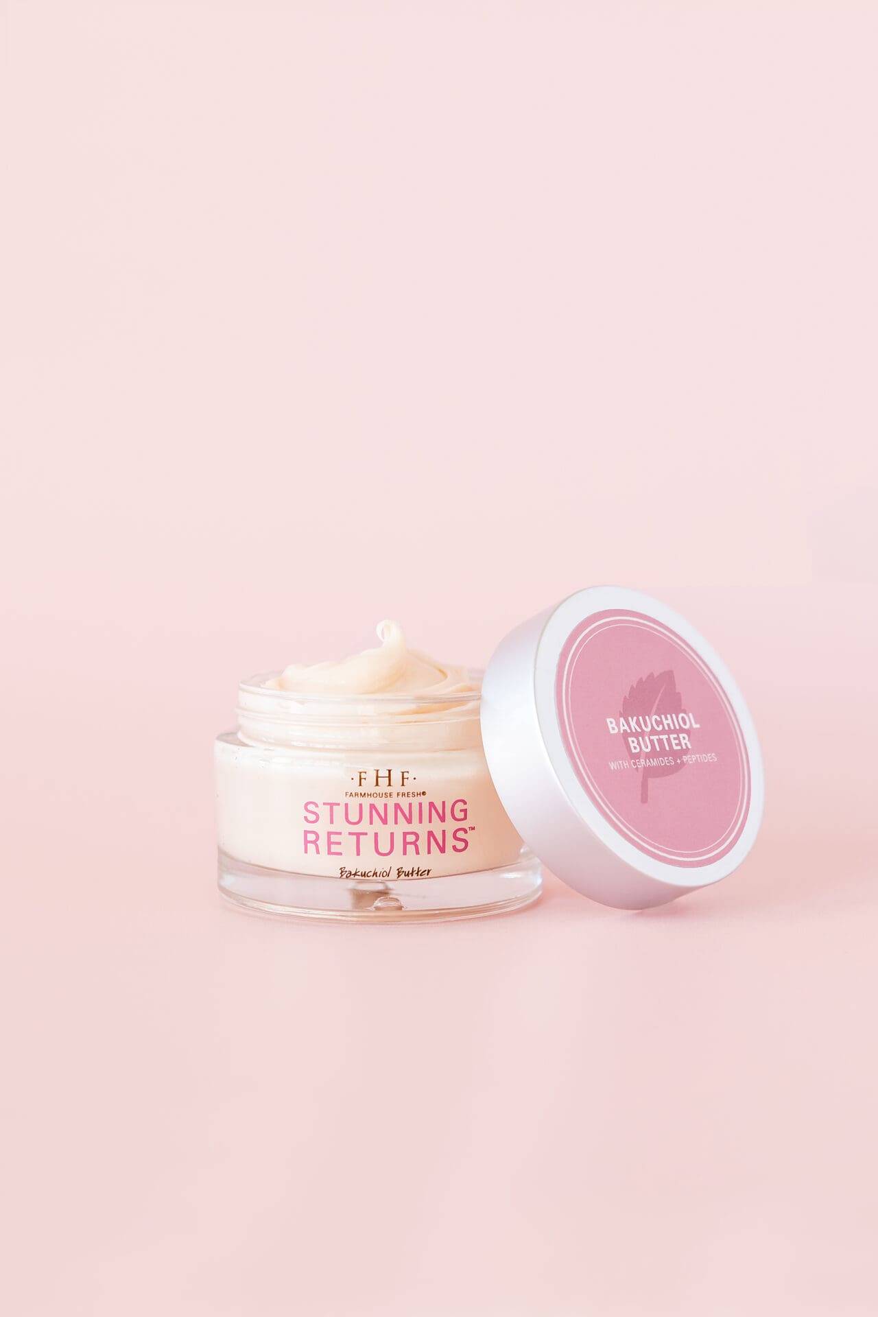 A pink and white container of cream sitting next to another container.