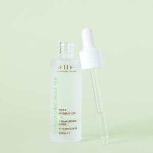 A bottle of serum next to a spray pump.