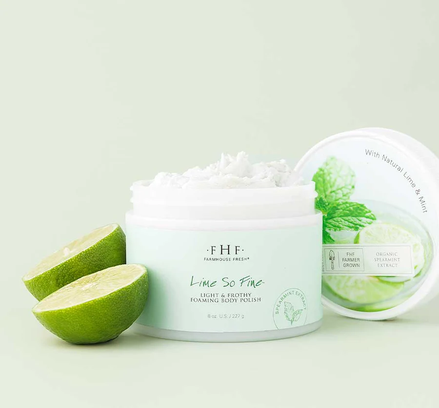A jar of body butter next to two limes.